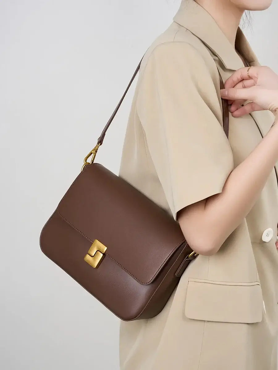 Stylish brown leather shoulder bag featuring a gold clasp, perfect for modern elegance and functionality.