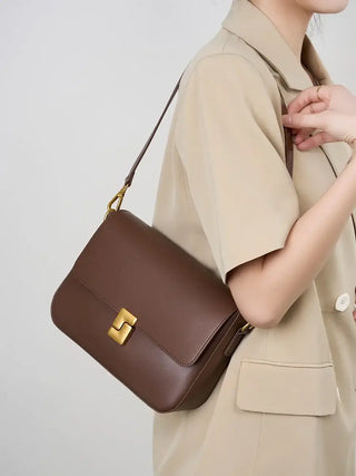 Stylish brown leather shoulder bag featuring a gold clasp, perfect for modern elegance and functionality.