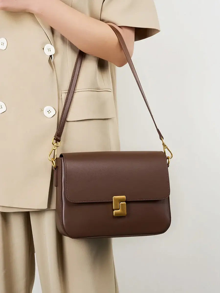 Brown leather shoulder bag with a stylish design and single strap, perfect for modern elegance and functionality.