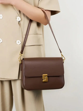 Brown leather shoulder bag with a stylish design and single strap, perfect for modern elegance and functionality.