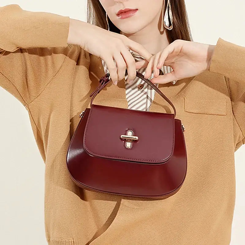 Elegant burgundy leather shoulder bag with decorative lock, perfect for casual and refined styles.