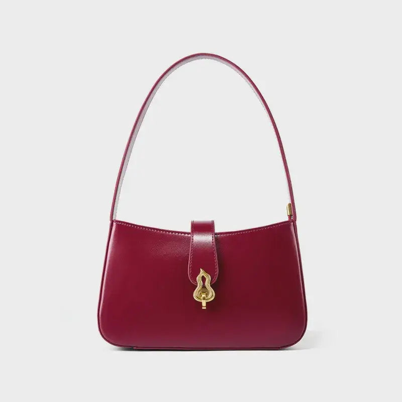 Burgundy leather shoulder bag with zipper closure and decorative lock, featuring a timeless half-moon silhouette.