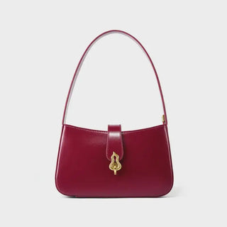 Burgundy leather shoulder bag with zipper closure and decorative lock, featuring a timeless half-moon silhouette.