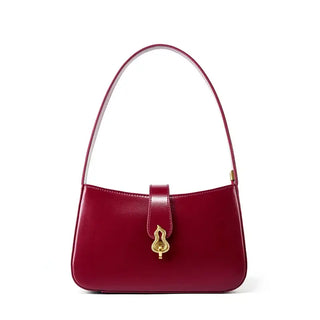 Leather shoulder bag in burgundy with zipper and decorative lock, perfect for sophisticated, minimalist style.