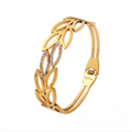 Gold bracelet with leaf-like design on a white background
