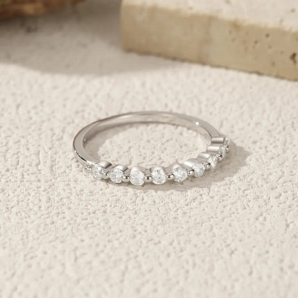 Geometric Moissanite Wedding Band Ring 925 Sterling Silver displayed on textured surface.