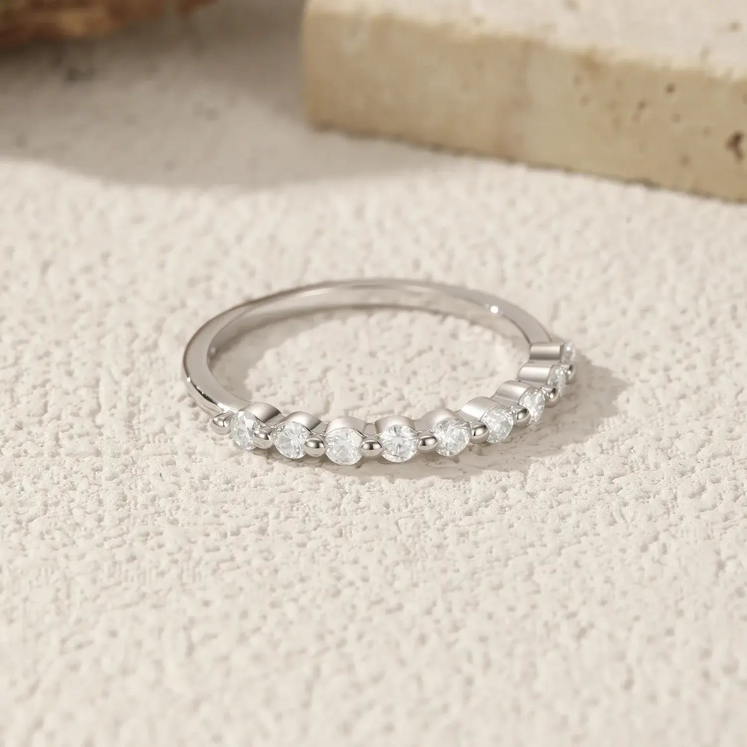 Geometric Moissanite Wedding Band Ring 925 Sterling Silver displayed on textured surface.
