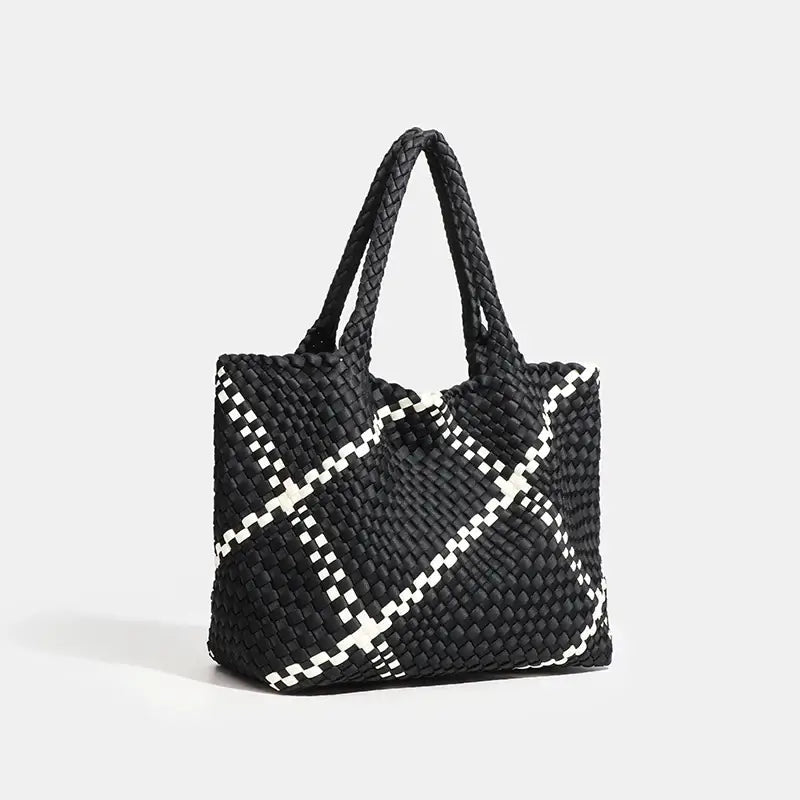 Woven shoulder bag in black with white striped criss-cross pattern, featuring a flap pocket for stylish everyday use.