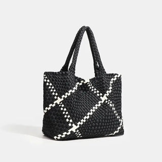 Woven shoulder bag in black with white striped criss-cross pattern, featuring a flap pocket for stylish everyday use.