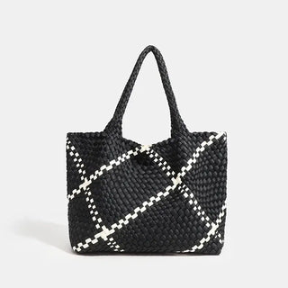 Woven shoulder bag in black with white criss-cross pattern, featuring a flap pocket for added functionality.