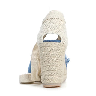Women's Denim Espadrilles featuring a woven ankle strap and high wedge heel from the back view.