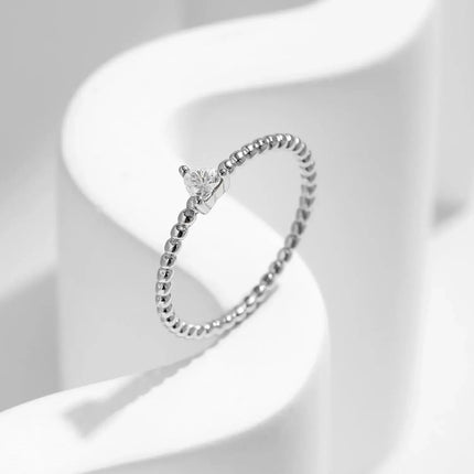Heart Moissanite Engagement Rings on a minimalist white background showcasing a delicate design.