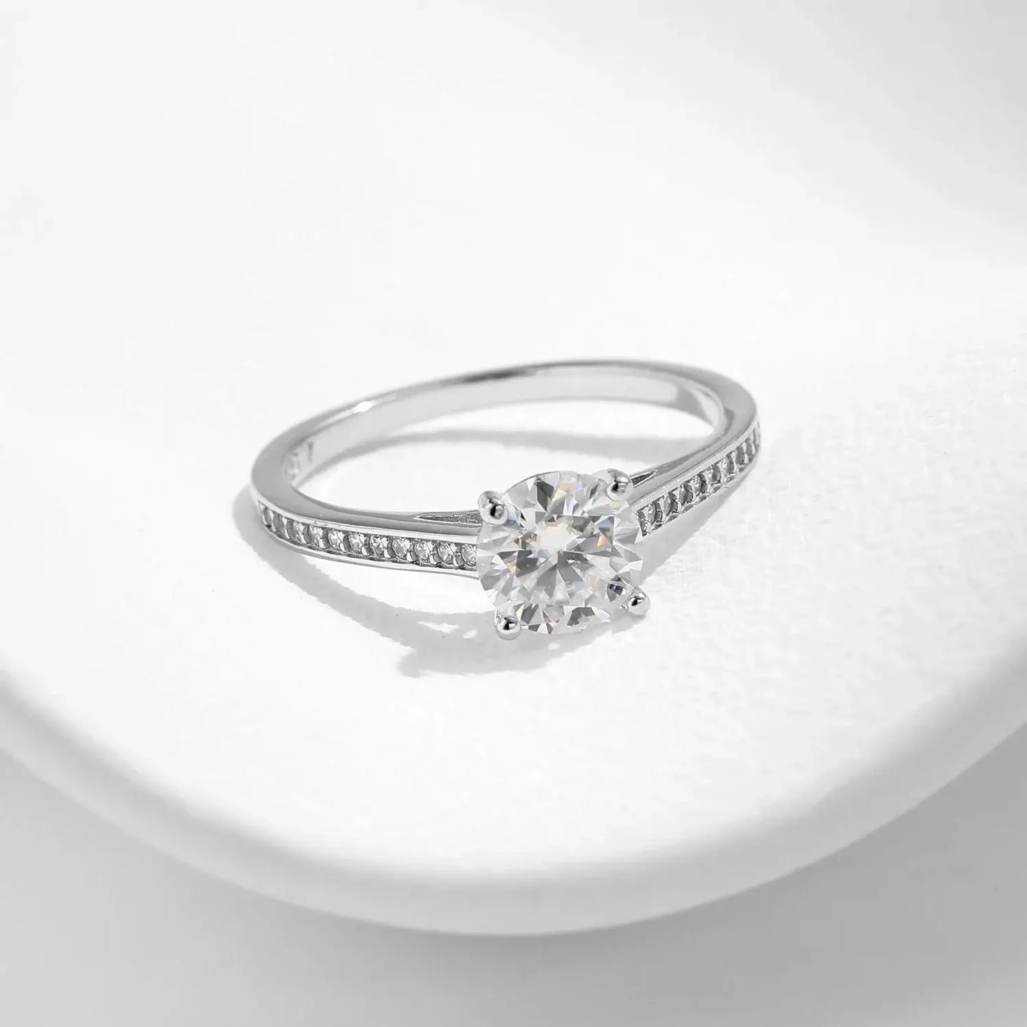 Lab Diamond 1CT Moissanite Ring set on a smooth surface, featuring a round moissanite surrounded by zircon side stones.