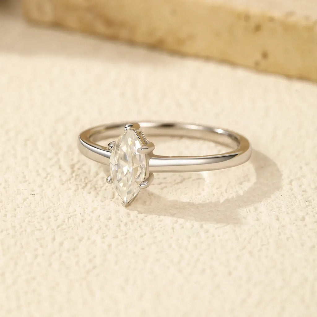 Marquise-cut Rhombic Moissanite Ring set on a textured surface highlighting its elegant design and sparkling stone.