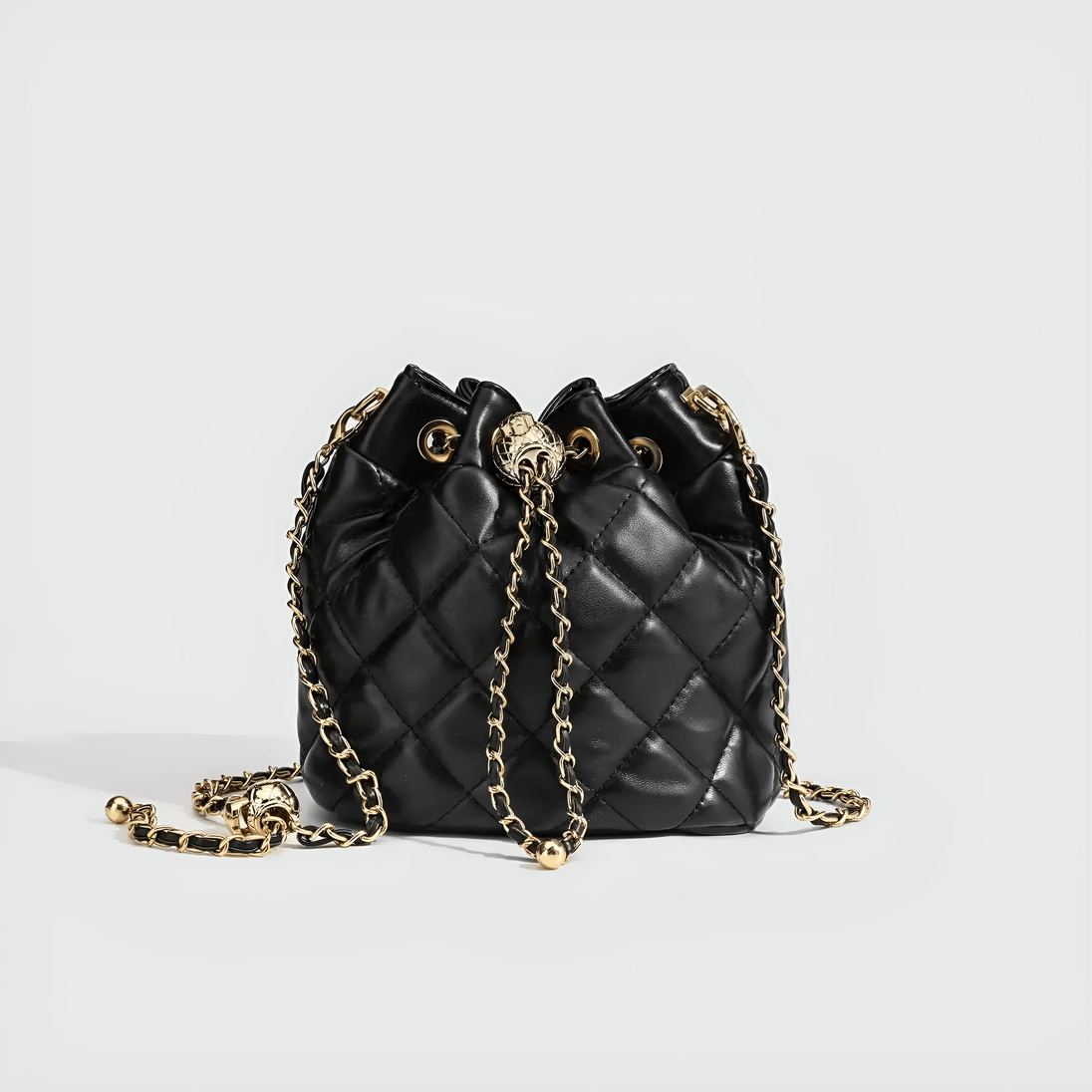 Black minimalist quilted drawstring bag with gold chain strap, perfect for any occasion.