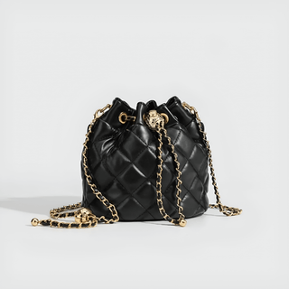 Minimalist black quilted drawstring bag with gold chain strap for chic everyday elegance.