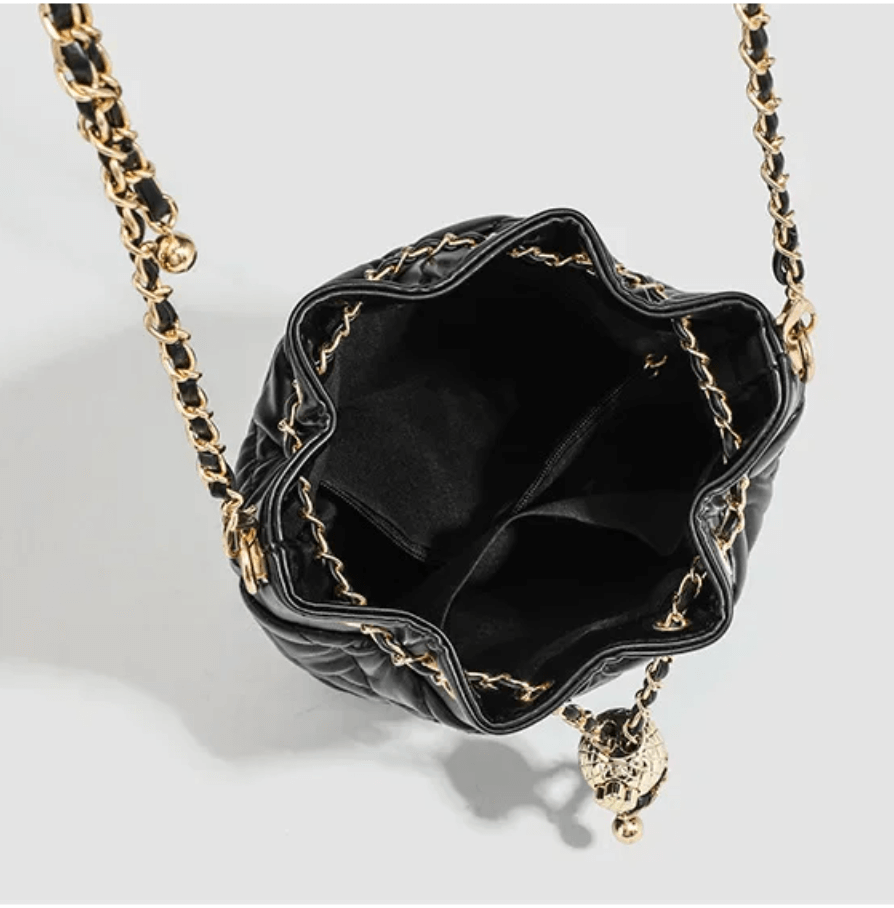Minimalist black quilted drawstring bag with a gold chain strap and a soft polyester interior.