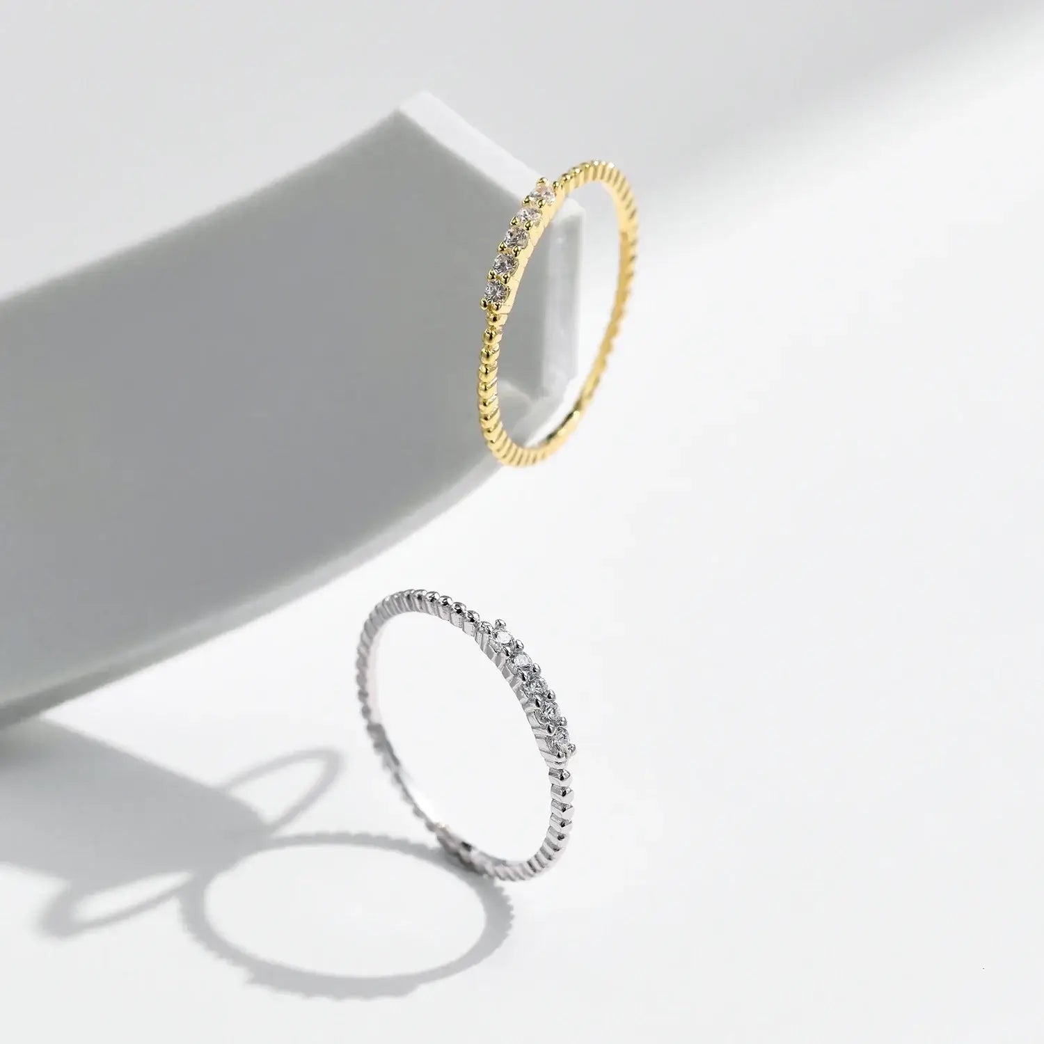 Moissanite Eternity Band Ring in 925 Sterling Silver displayed alongside a gold ring, highlighting elegant design and sparkle.