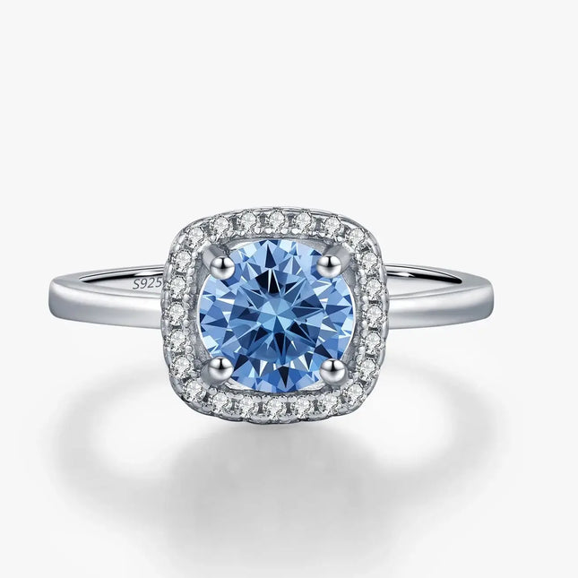 Moissanite Halo Ring in 925 Sterling Silver featuring a round-cut blue stone and shimmering accents.