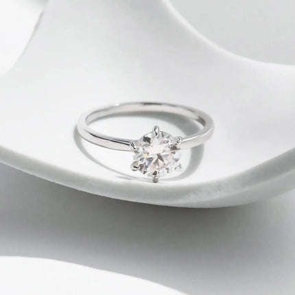 Moissanite Lab Diamond Ring on a white surface showcasing its stunning round moissanite in a classic prong setting.
