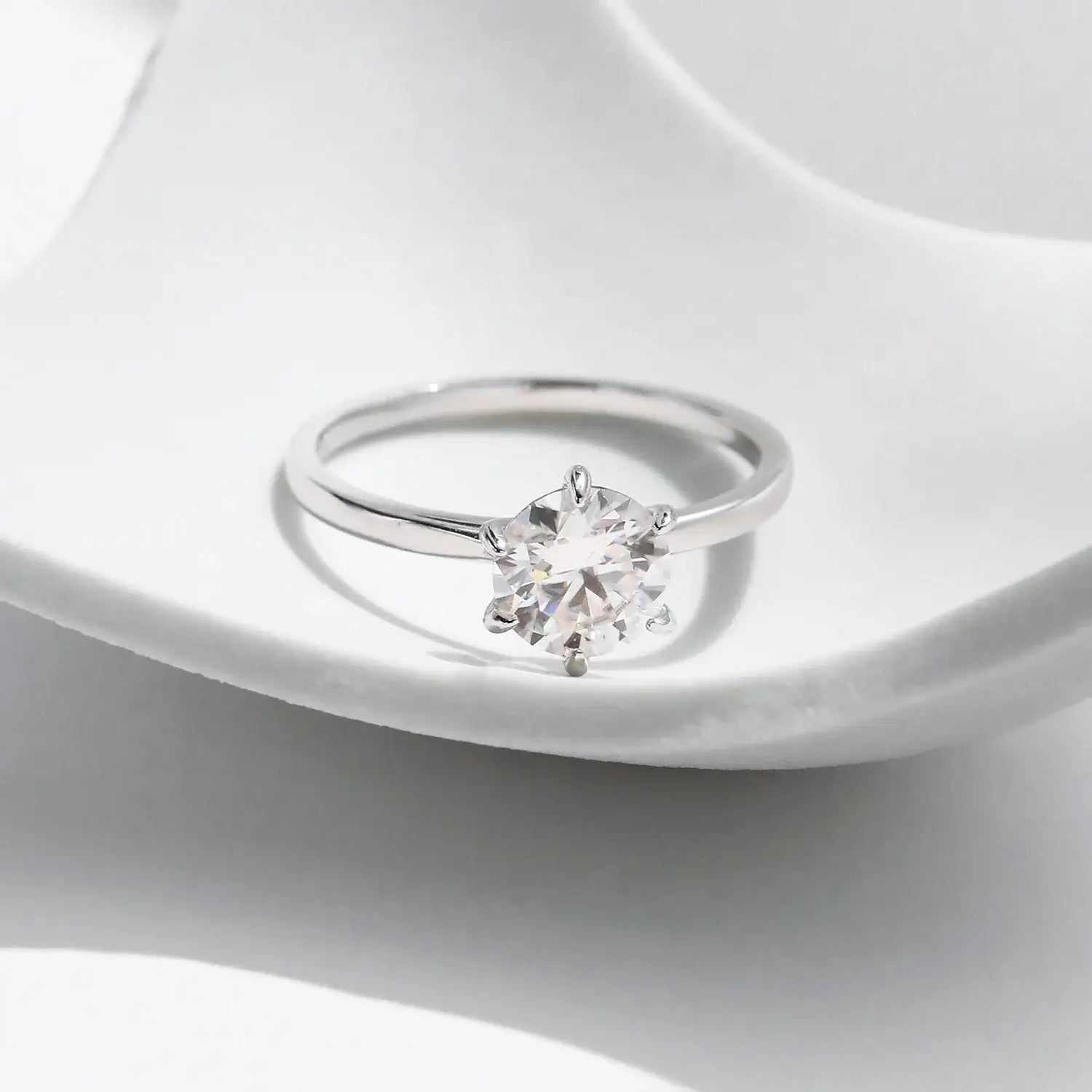 Moissanite Lab Diamond Ring on a white surface showcasing its stunning round moissanite in a classic prong setting.