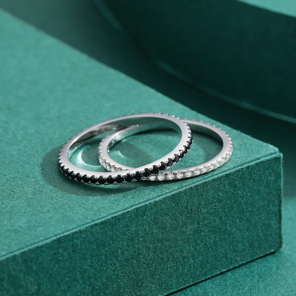 Pave Zircon Ring 925 Sterling Silver displayed with black and white zircon stacking rings on green background.