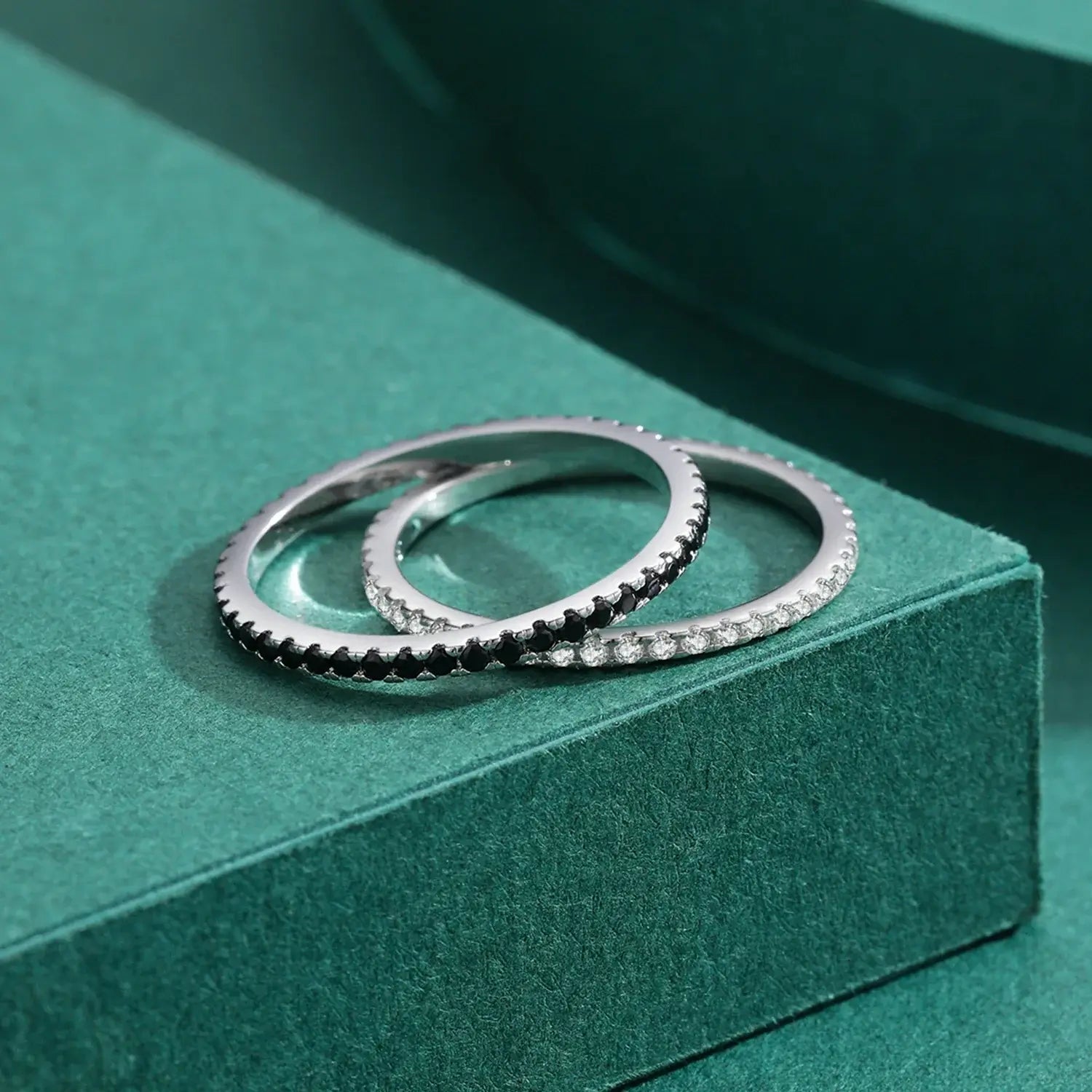 Pave Zircon Ring 925 Sterling Silver displayed with black and white zircon stacking rings on green background.