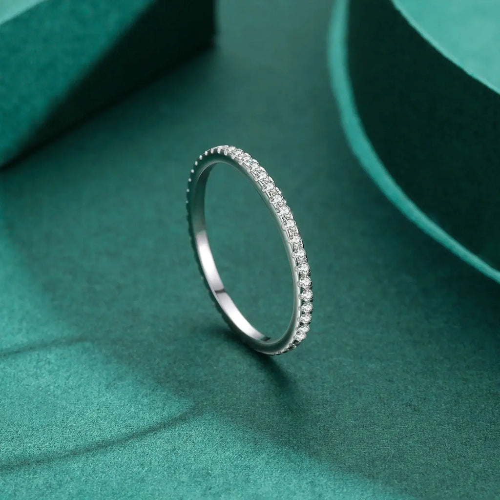 Pave Zircon Ring 925 Sterling Silver with sparkling zircon stones in a sleek design on a teal background.