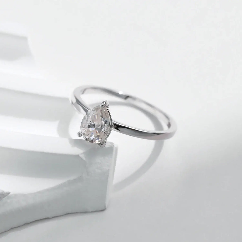 Pear Cut Moissanite Ring 925 Sterling Silver displayed on a white background, showcasing the elegant design and shine.