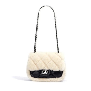 Elegant cream-colored handbag with a quilted design and black satin strap, perfect for stylish crossbody wear.