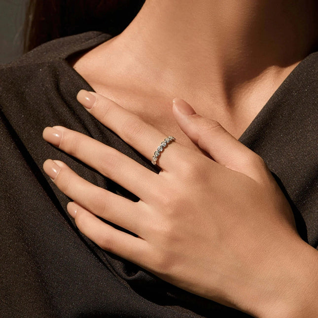 Round Moissanite Eternity Ring 925 Sterling Silver worn on elegant female hand, showcasing dazzling moissanite stones.