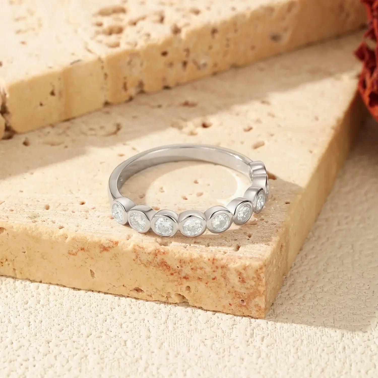 Round Moissanite Eternity Ring 925 Sterling Silver set against a textured background showcasing its elegant design.