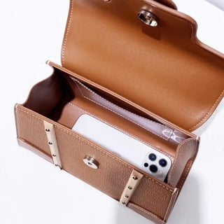 Handbag with wooden handle and rivet decoration, showing the interior and a smartphone inside.