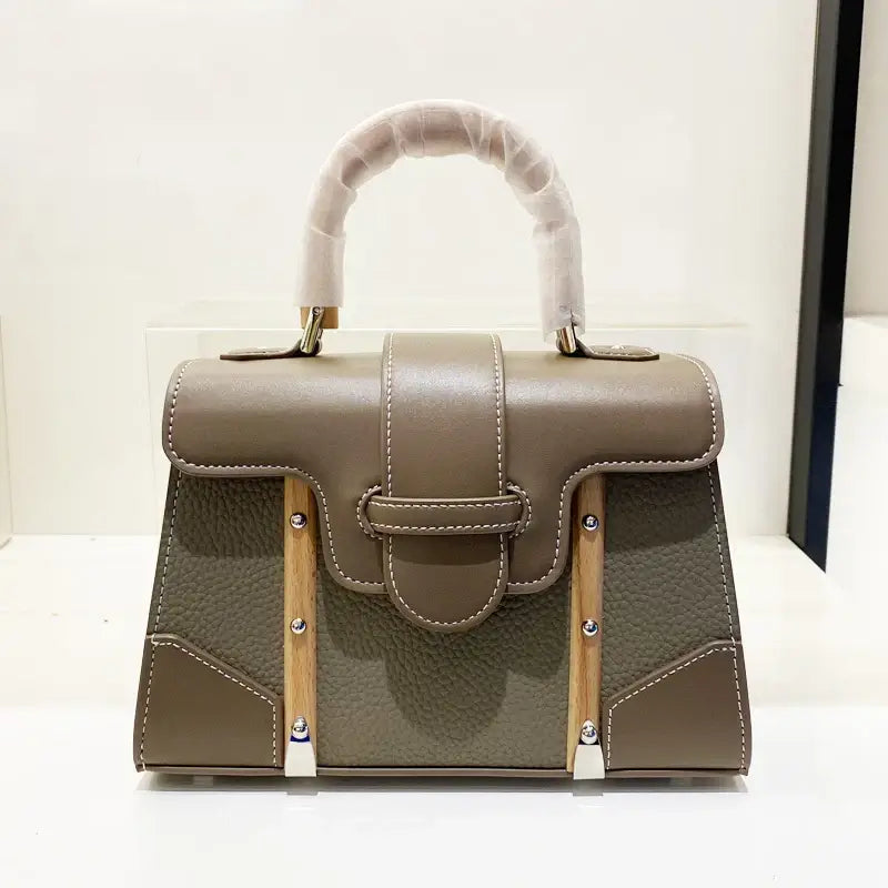 Handbag with wooden handle and rivet decoration perfect for women, showcasing a stylish and hard design in a beige color.