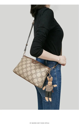 Monogram Crossbody Bag with Cute Bunny Charm worn as a stylish messenger bag, showcasing its geometric pattern and adorable charm.