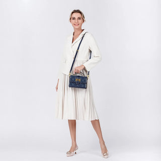 Model wearing a white outfit holding a Shoulder Crossbody Bag Navy Blue with Gold Detail, showcasing an elegant style.