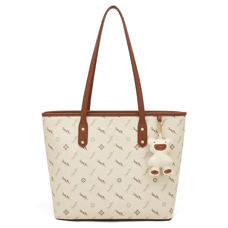 Shopper Bag with cute bear keychain charm in beige with brown straps and animal print design.