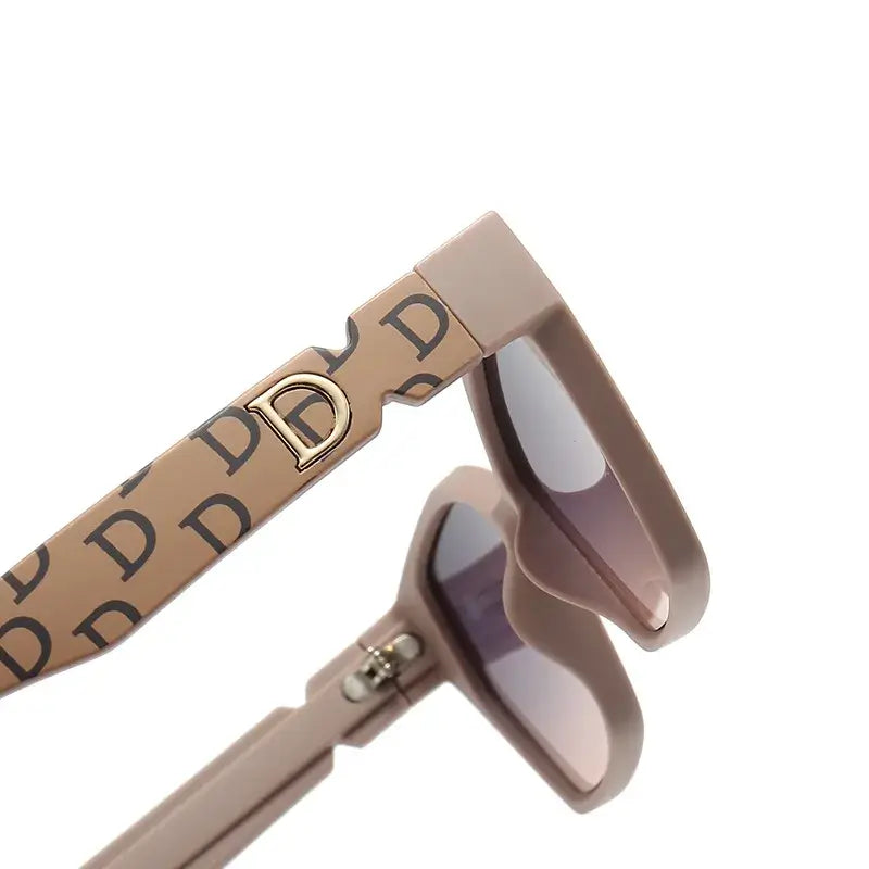 Women's sunglasses with stylish beige frames featuring a logo design and tinted lenses.