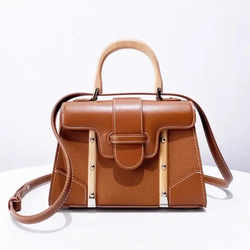 Handbag with wooden handle and rivet decoration designed for women. Hard exterior closure type cover.