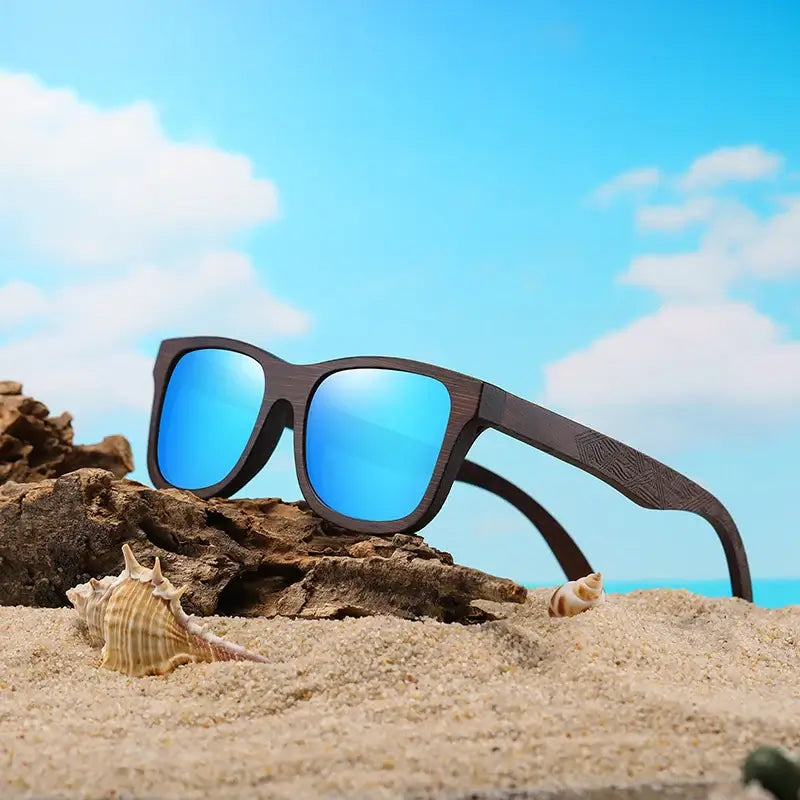 Sunglasses Bamboo on the beach with blue lenses and wooden frame, perfect for outdoor activities.