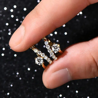 Moissanite Diamond Round Earrings for Women held between fingers on a sparkling background.