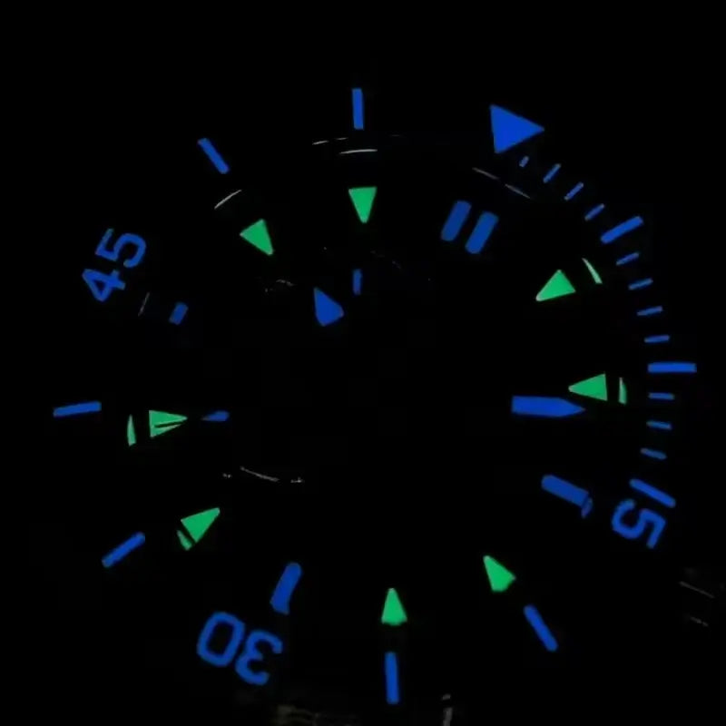 Mens Wristwatch glowing blue and green dial in the dark, showcasing the unique design and features.