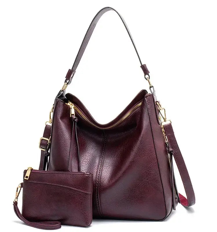 Hobo shoulder bag with a matching wallet pouch in a rich burgundy color, featuring gold-tone hardware and a stylish design.