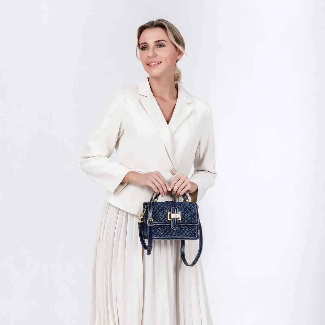 Shoulder Crossbody Bag in navy blue with gold detail, held by a woman wearing a white blazer and skirt.