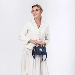 Shoulder Crossbody Bag in navy blue with gold detail, held by a woman wearing a white blazer and skirt.