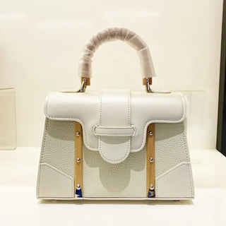Handbag with wooden handle and rivet decoration, stylish accessory for women, featuring a cover closure and hard exterior.