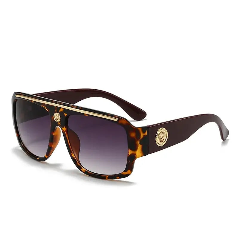 Sunglasses with gold detailing, featuring a trendy tortoiseshell frame and gradient lenses.