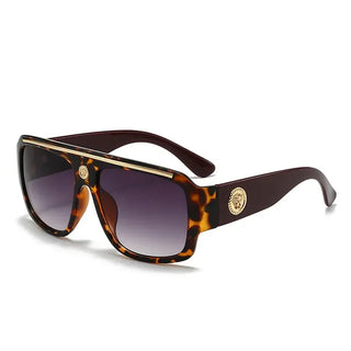 Sunglasses with gold detailing, featuring a trendy tortoiseshell frame and gradient lenses.