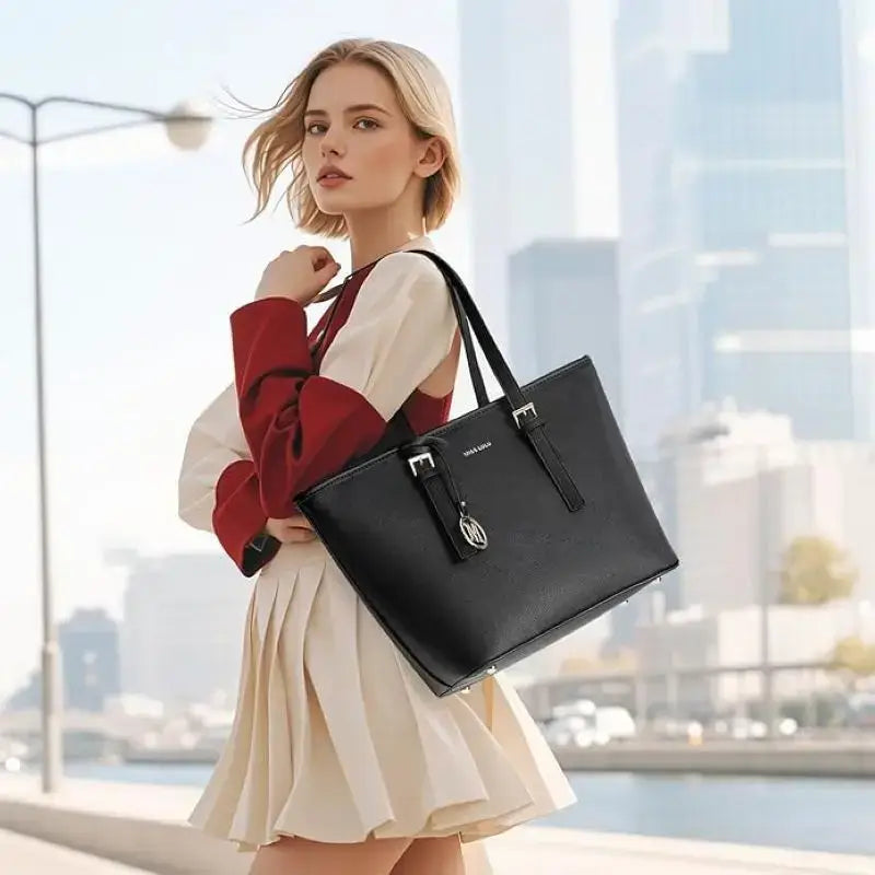 Large Shopper Tote Bag in black leather with stylish gold accents, showcased by a woman in a cityscape.