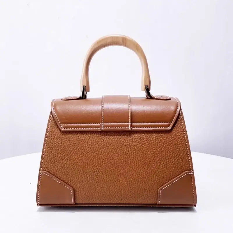 Handbag with wooden handle and rivet decoration, perfect accessory for women, hard exterior and stylish design.